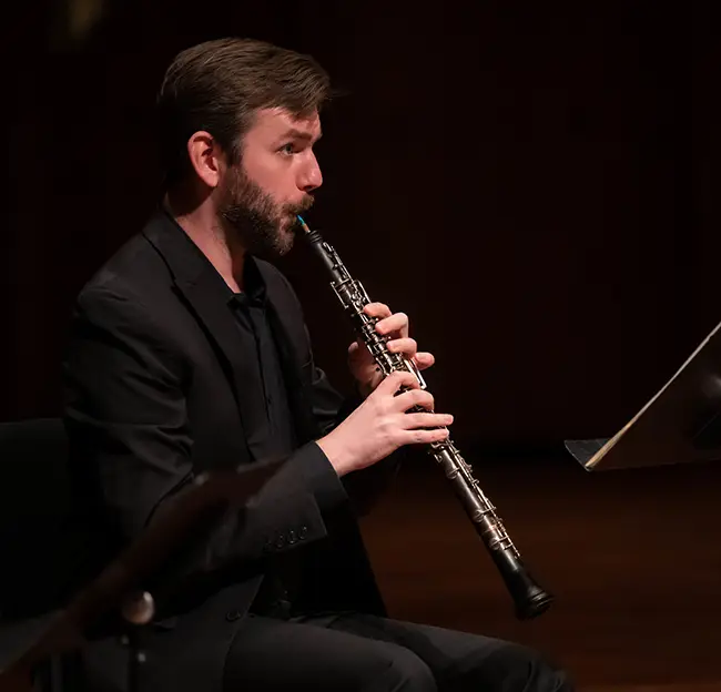 Man playing clarinet in profile