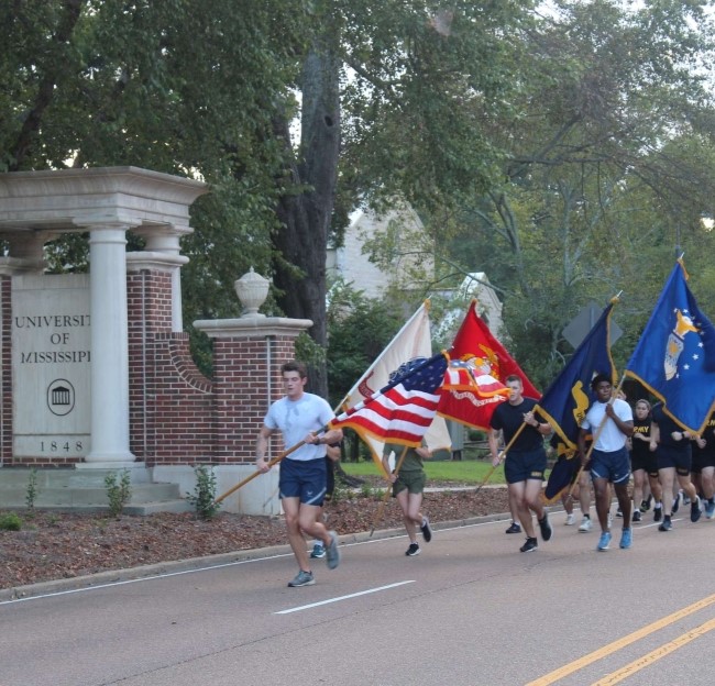 image of students on a run while carrying flags