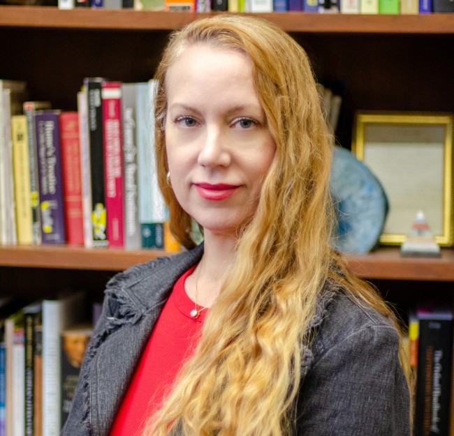 Deborah Mower standing in front of bookshelves