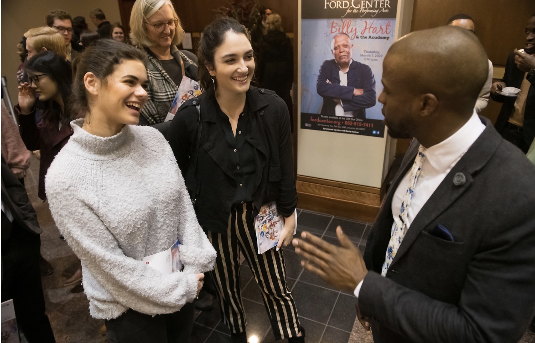 alumnus greets students at campus event