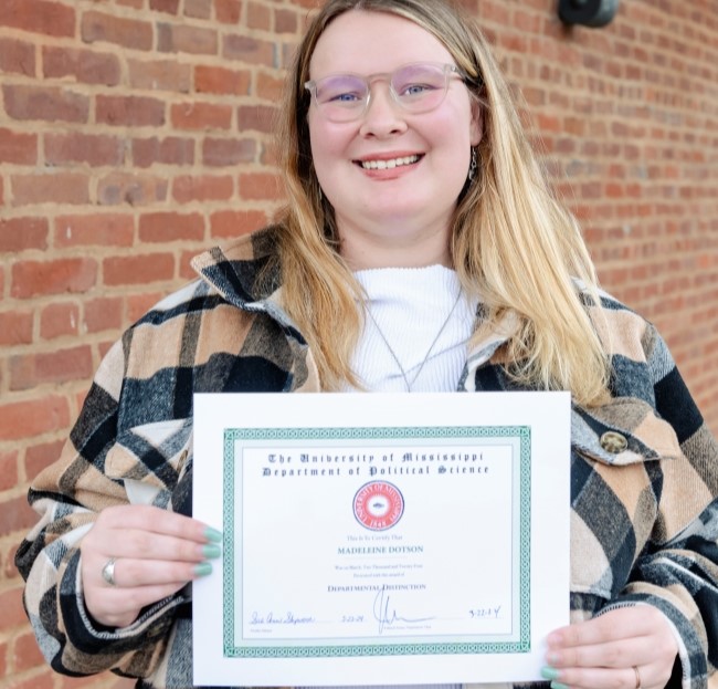 image of a student holding a certificate and smiling at the camera