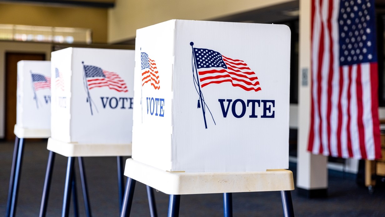 image of voter booth with cardboard privacy shields that have the American flag 