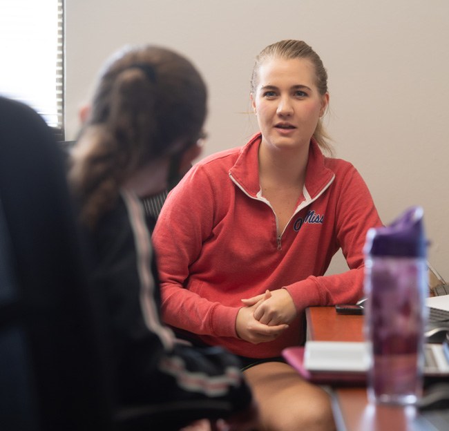 female sitting and talking with another person
