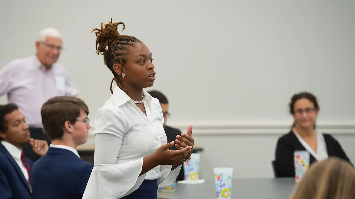 Student turned to side presenting to people around her.