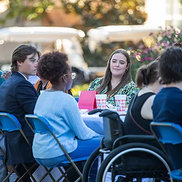 students outside having meal together happy