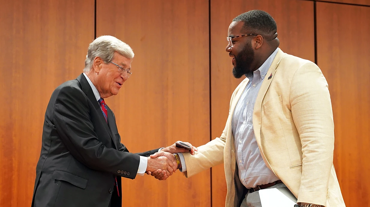 Two men shake hands