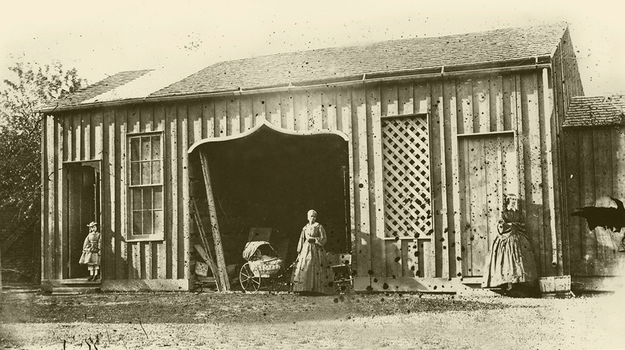 people standing outside of carriage house