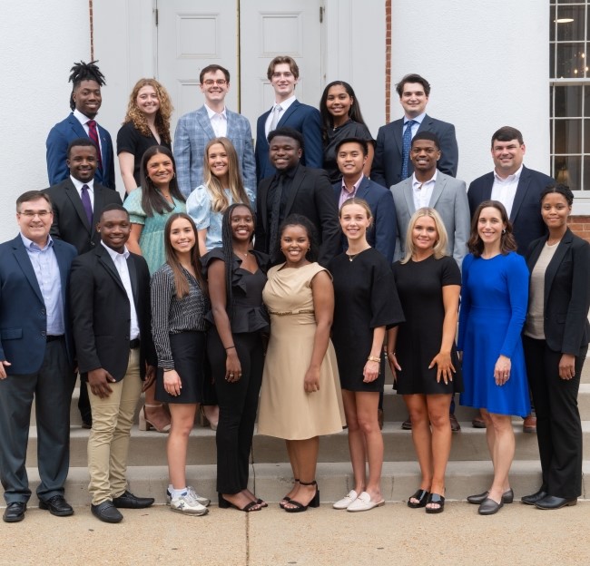 group of students standing on the steps of the university Lyceum with the Grisham-McLean director