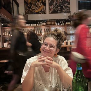 greta koshenina portrait; sitting at table, hands under chin