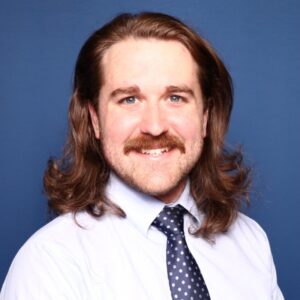 Logan Kirkland in tie against blue background