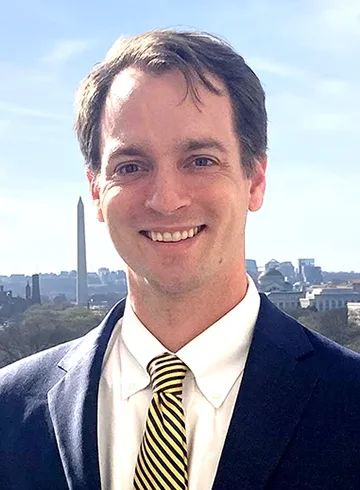 person standing outside with Washington monument in background