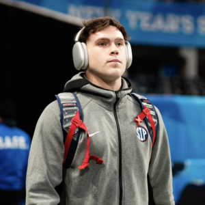 portrait of Zach Johansen on football field sideline wearing ear phones