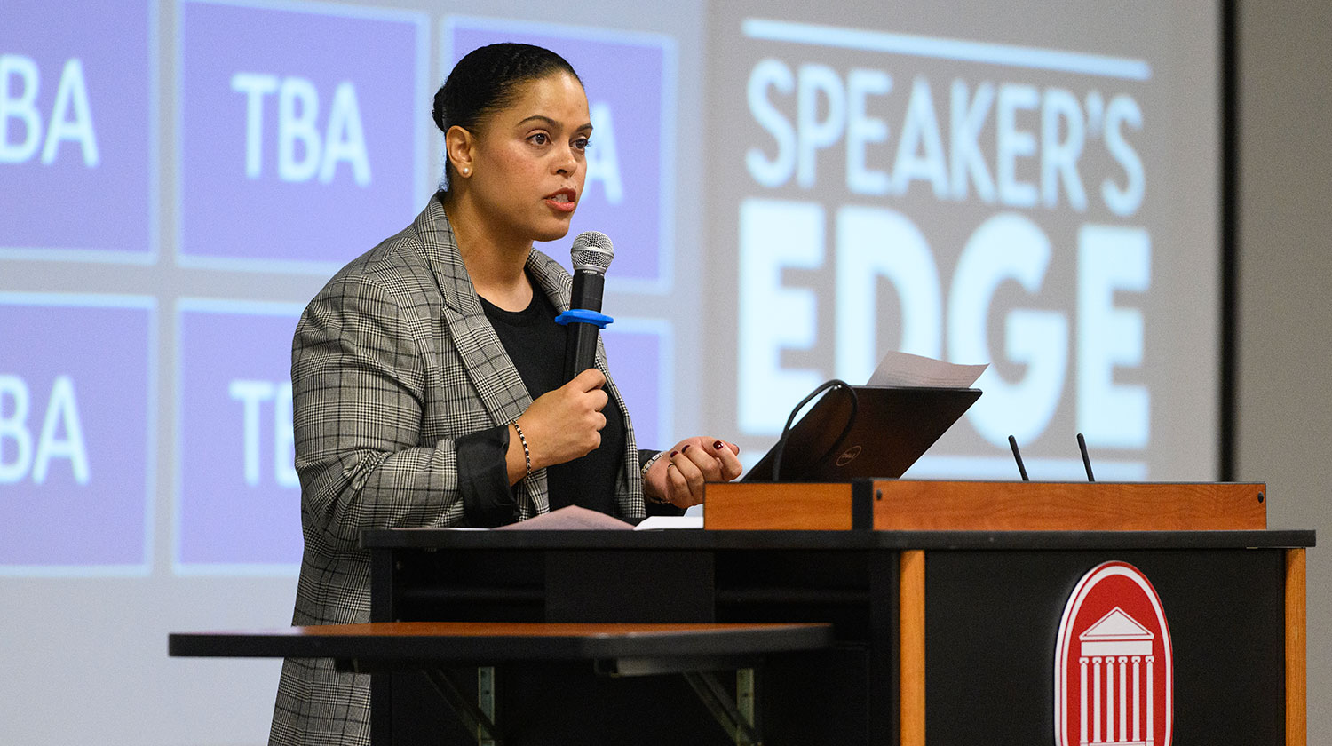 woman standing on stage holding a microphone
