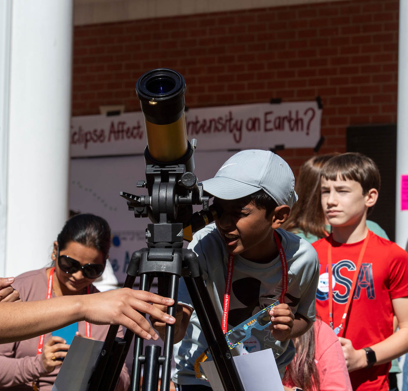 young boy looking through a telescope