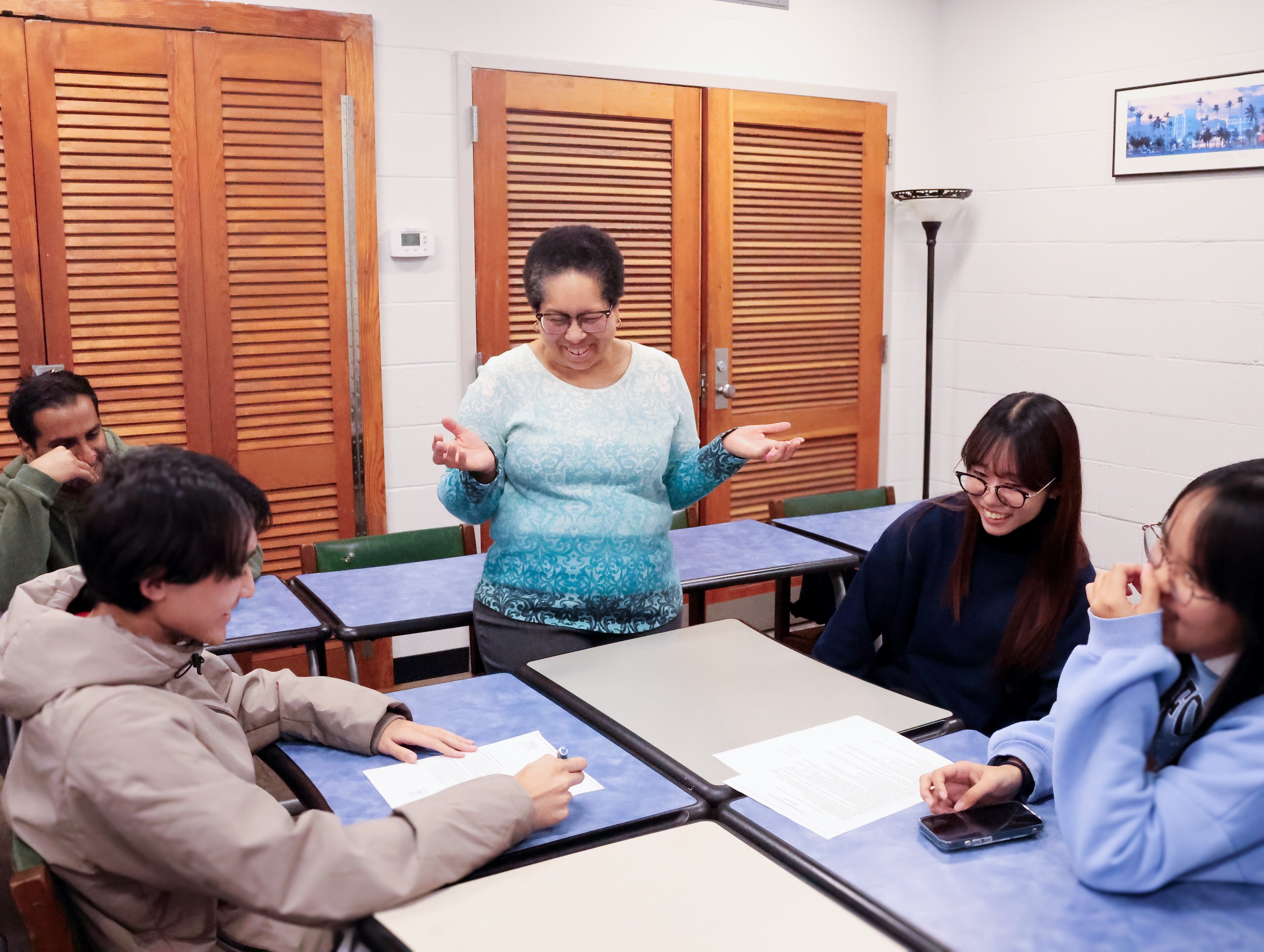 Instructor Velsie Pate laughs with IEP students during class instruction