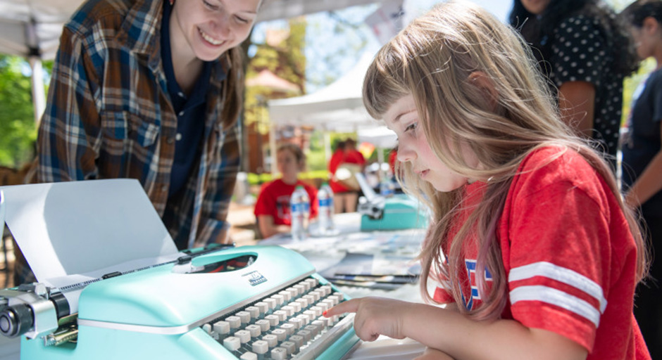 A young student types on a typewriter during Mississippi Day 2024