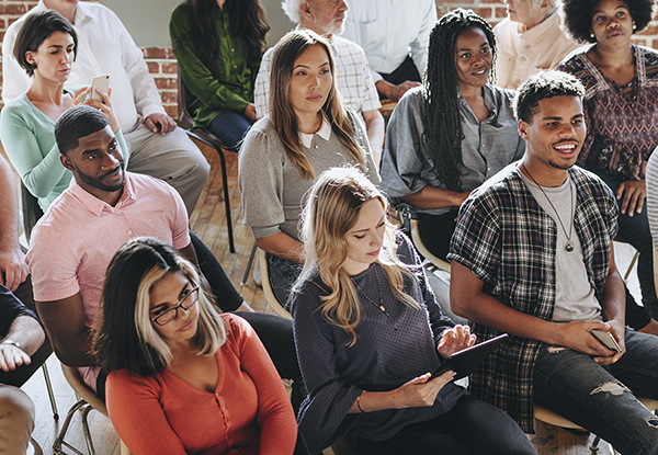 Diverse group of individuals sitting and listening to a presentation