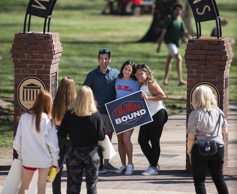 A family poses at the Walk of Champions on a campus visit.