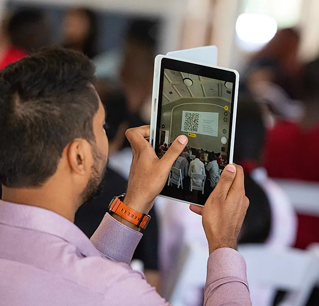 An orientation participant scanning a QR code with an iPad