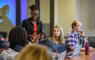 Several people are speaking to each other in a conference room.