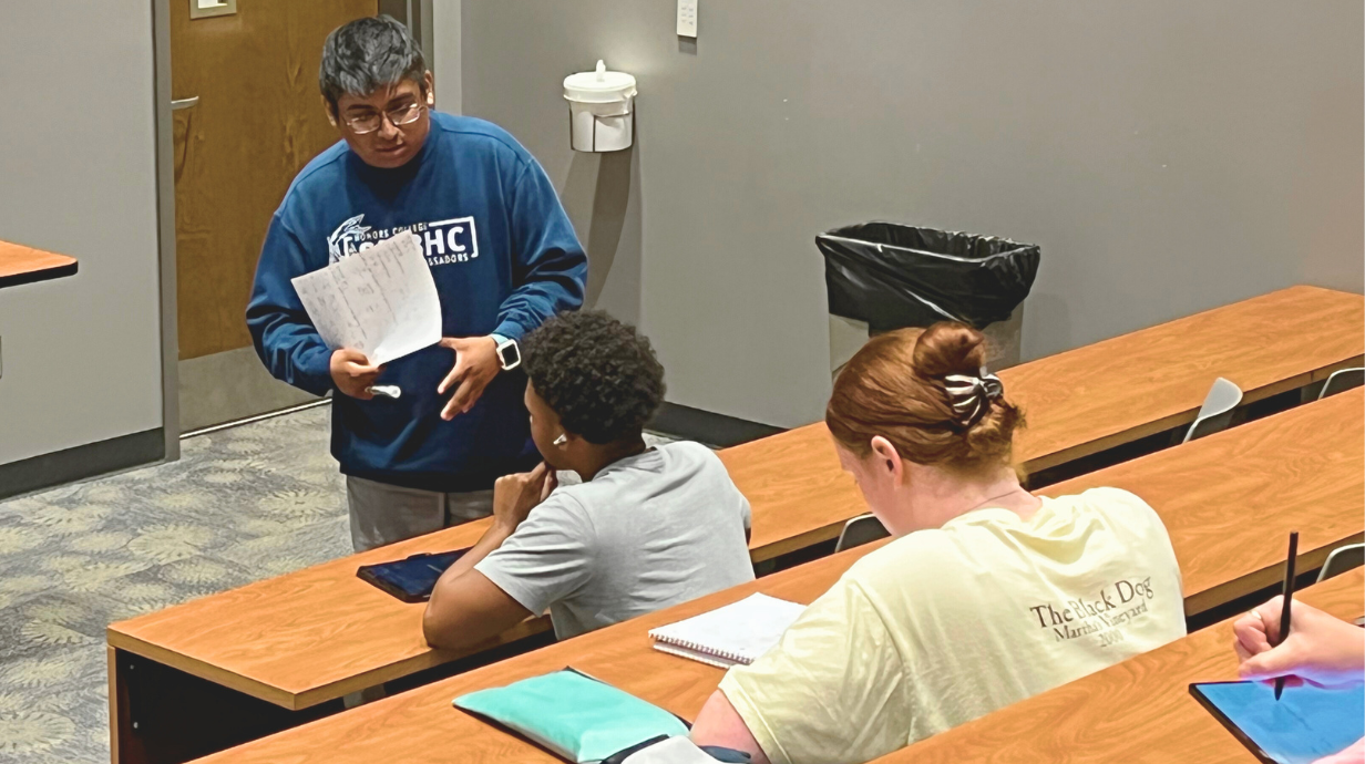 An undergraduate SI leader conducting a review session with two other students