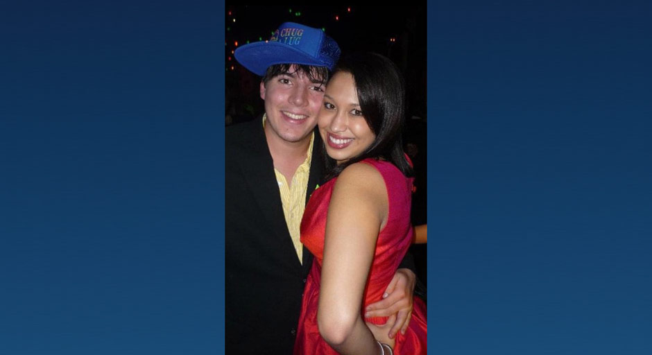 A young man and woman pose for a photo at a formal.