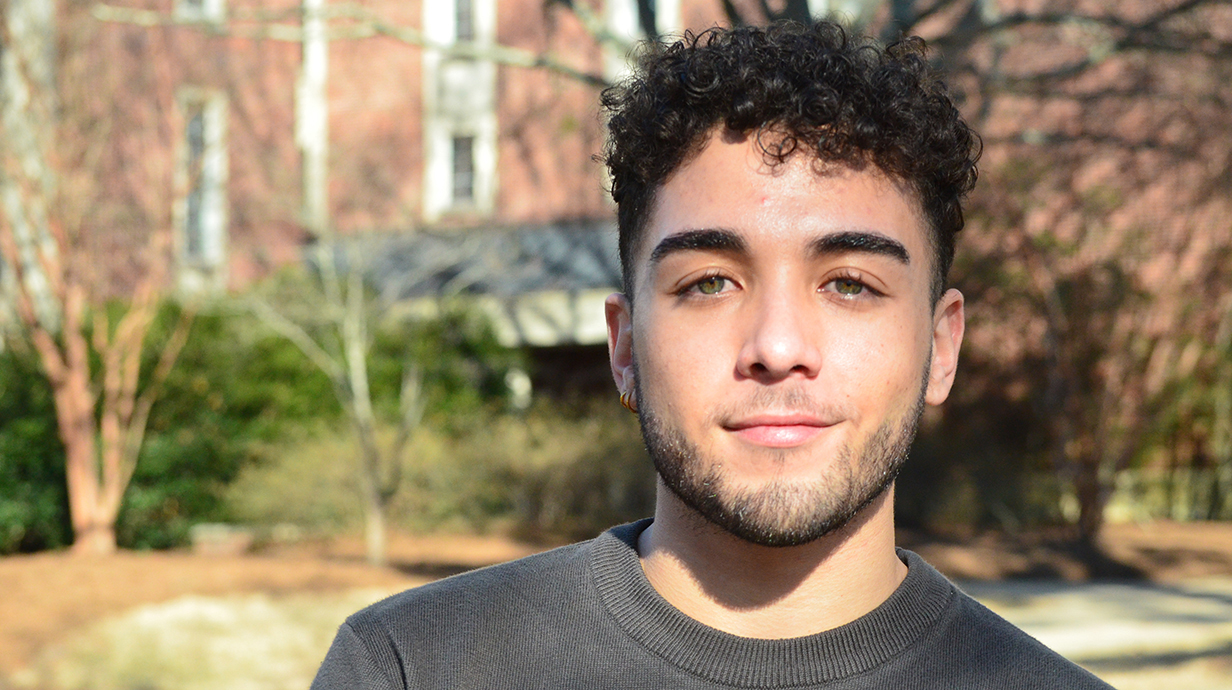 A young man poses for an outdoor photo.