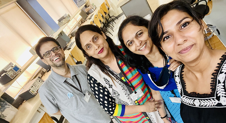 Three women and a man pose for a selfie.