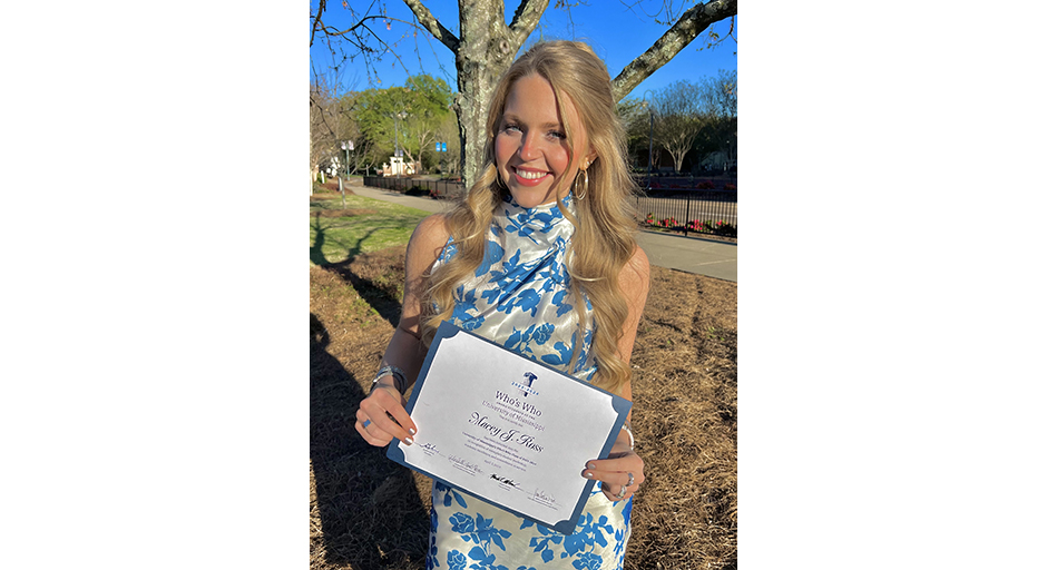 A young woman smiles and shows off an award certificate.