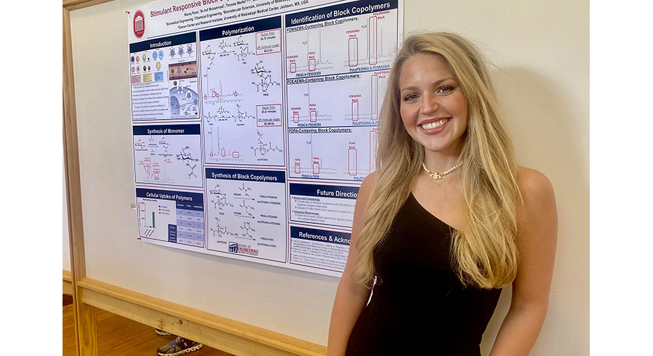 A young woman in a black dress stands in front of a research poster.