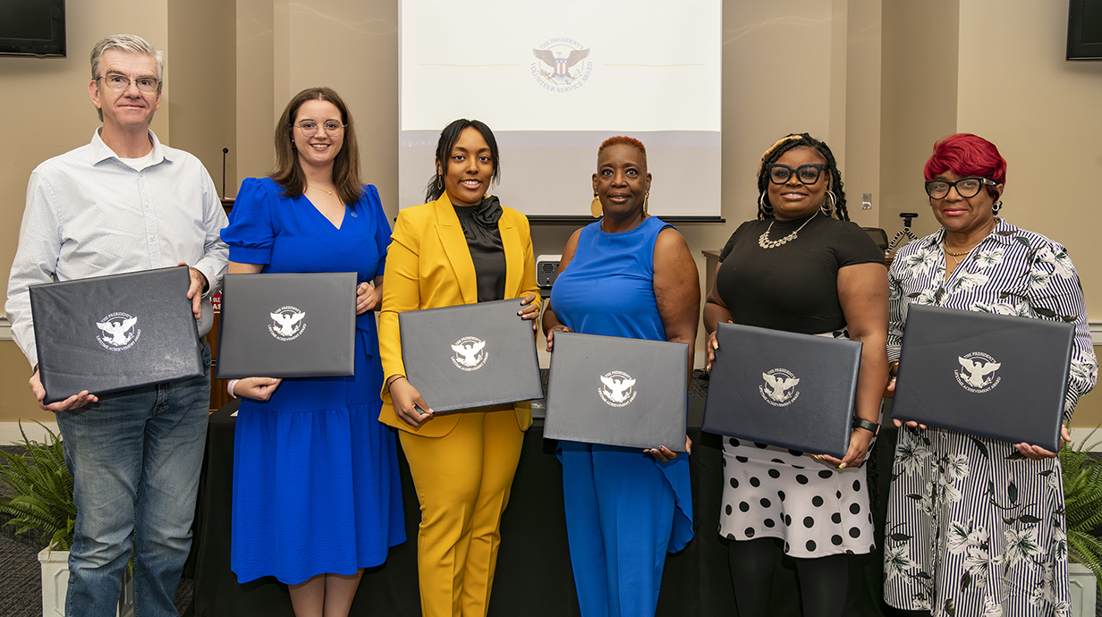 Awardees of the President's Volunteer Service Award for Lifetime Achievement, past and present members of the North Mississippi VISTA Project, pose for a picture with their awards.