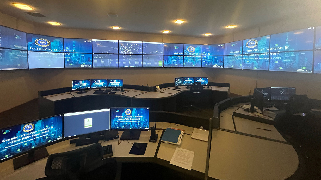 Photo of a police department control center loaded with television screens and computers.