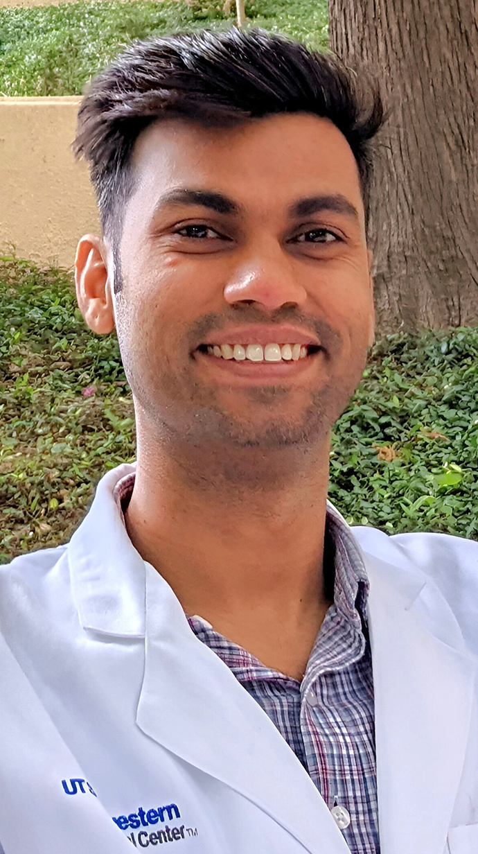 Headshot of a man wearing a white lab coat.