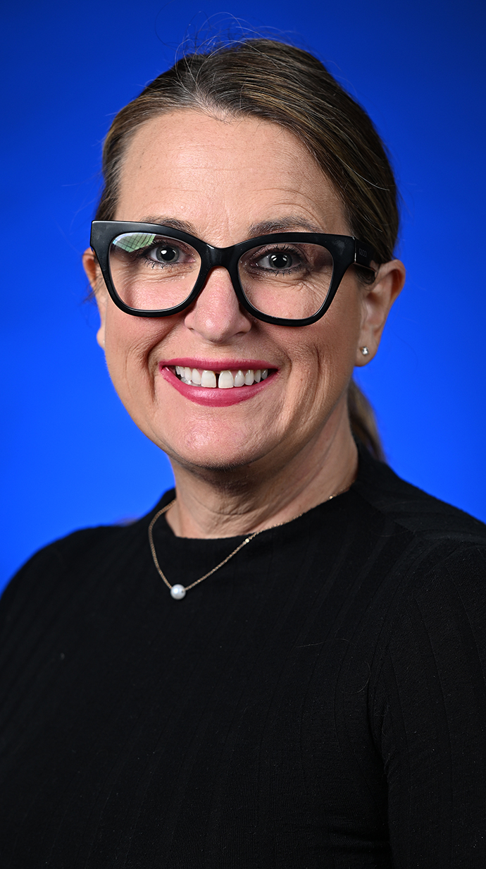 Headshot of a woman wearing glasses and a black blouse.