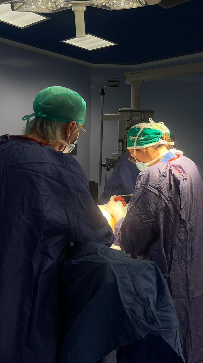 Doctors cluster around a patient in a surgical room of a hospital.