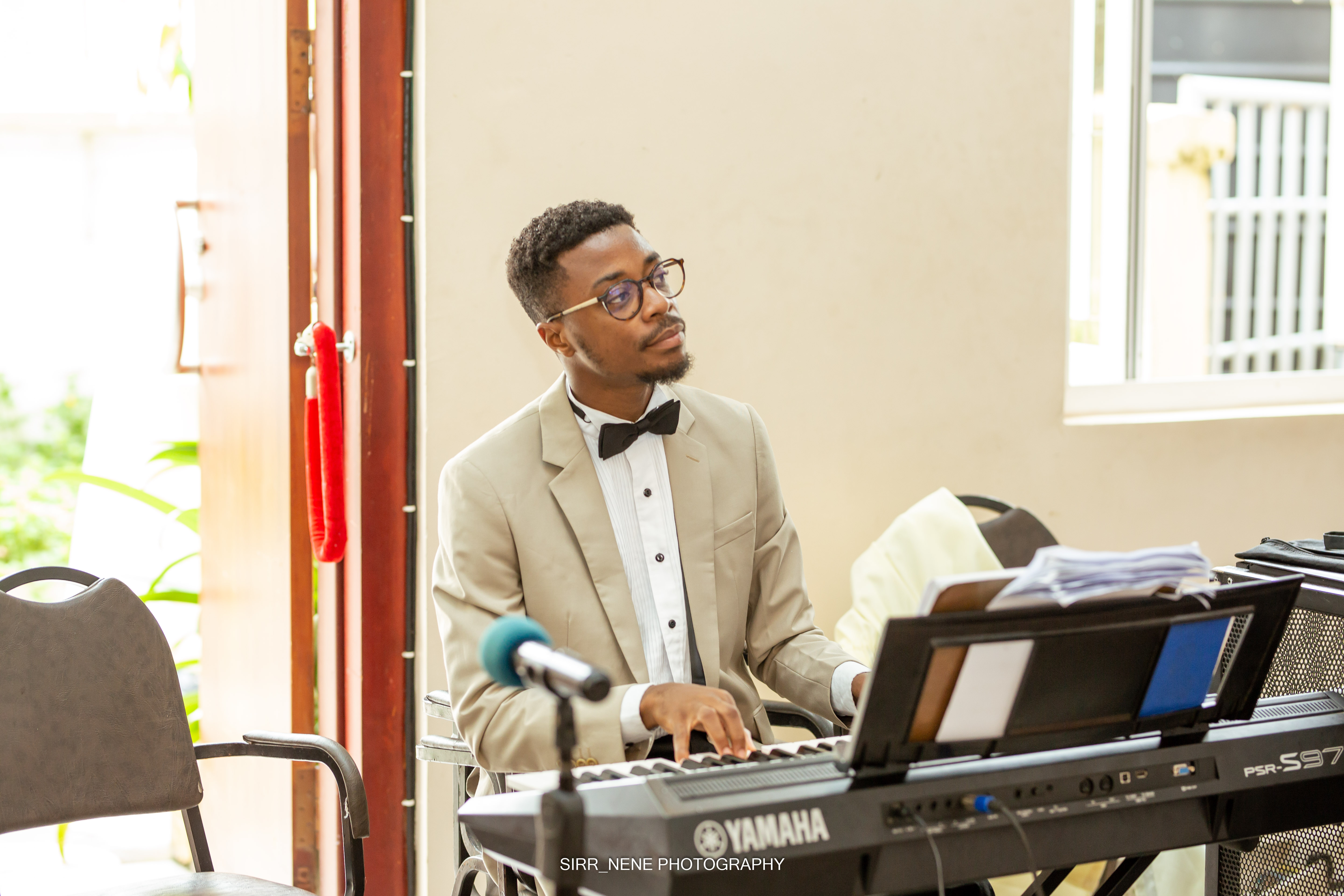 An image of Ransford Addae playing a piano in a church.