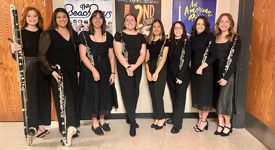 Eight musicians holding clarinets standing together for a photo