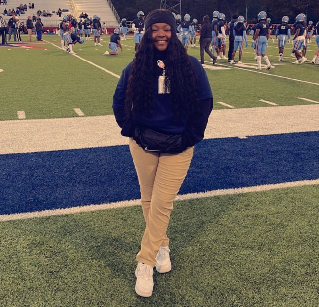 Topanga Taylor poses in front of the Memphis State Tigers' football team.