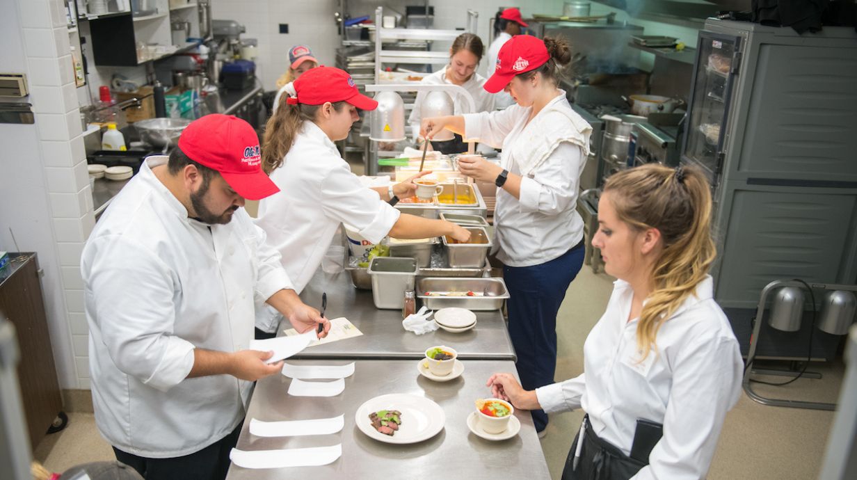 hospitality students work in an industrial kitchen