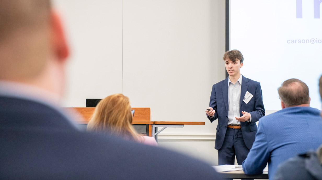  Young man presenting in front of judges during the Gillespie Business Plan Competition.