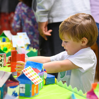 Young boy examines an illuminated art display.