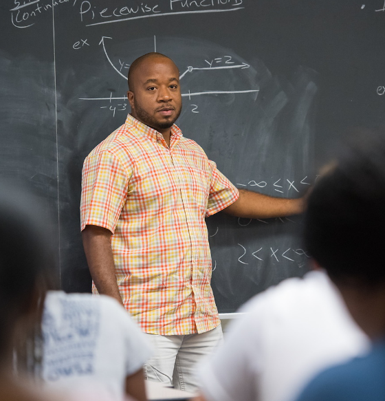 Professor writes formulas on a chalkboard.