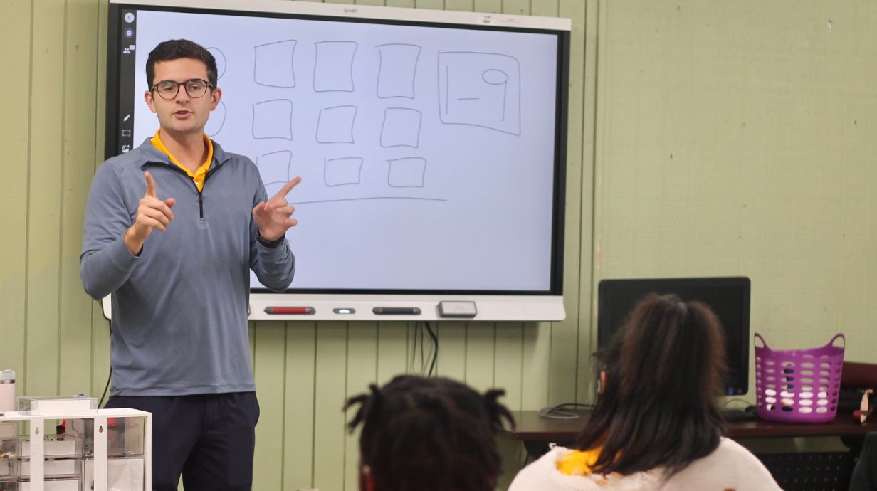 Teacher instructing students in front of classroom