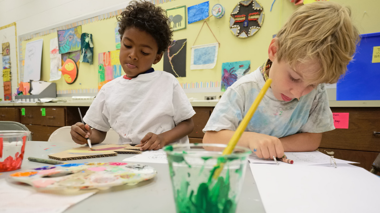 Two children play with paint.