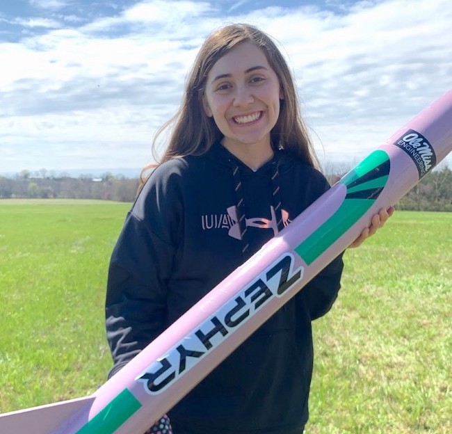 An Ole Miss chemical engineering student poses with a model rocket she is about to launch.