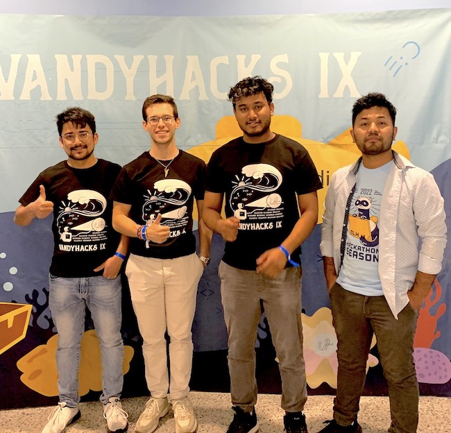 Computer science students at VandyHacks pose for a group photo giving a thumbs up.