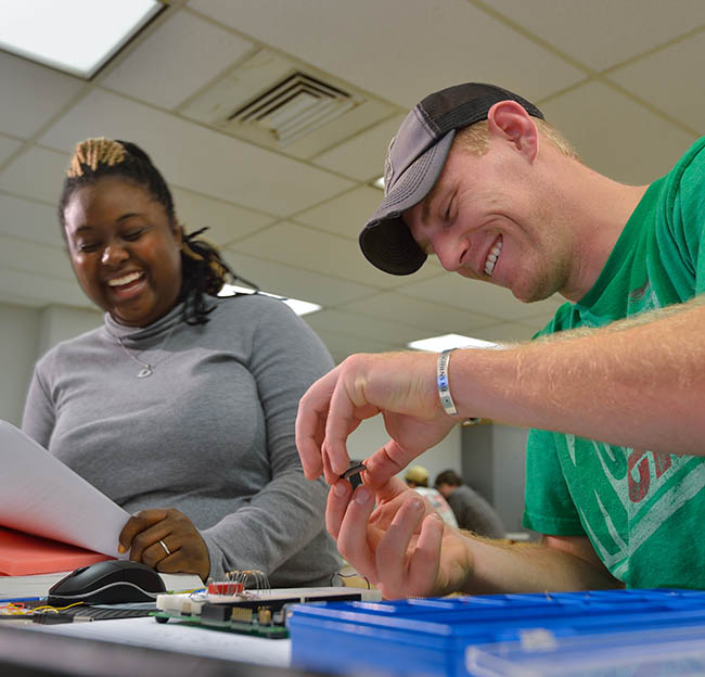 Two Ole Miss engineering students work at a lab station on a research project.