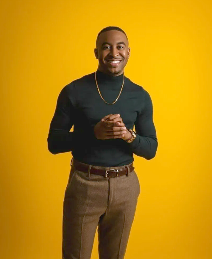 A.J. Norwood standing in front of a yellow background.