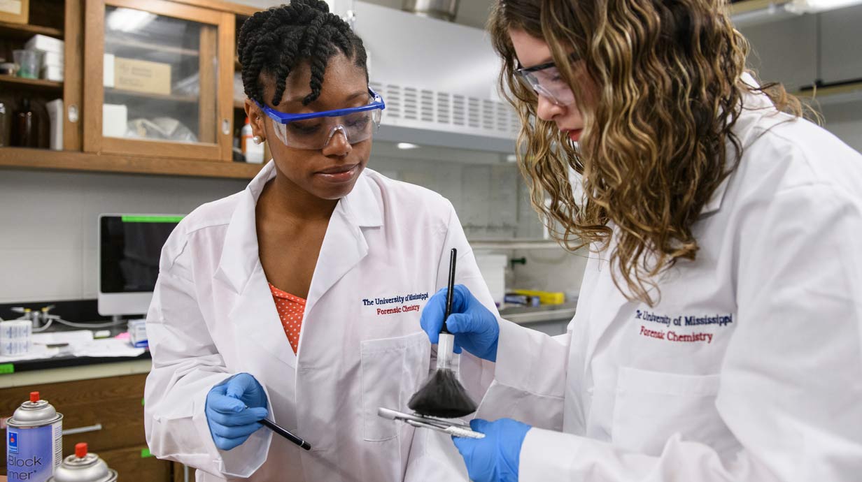 Students work together in a lab dusting for fingerprints.