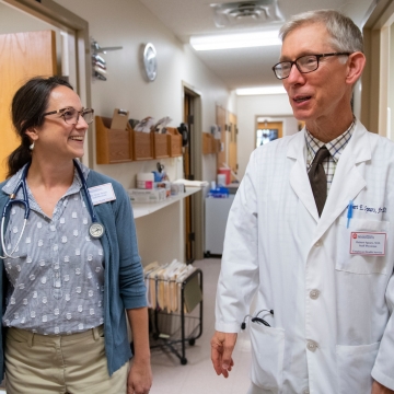 Two doctors walking and talking in the hall of the University Health Center.